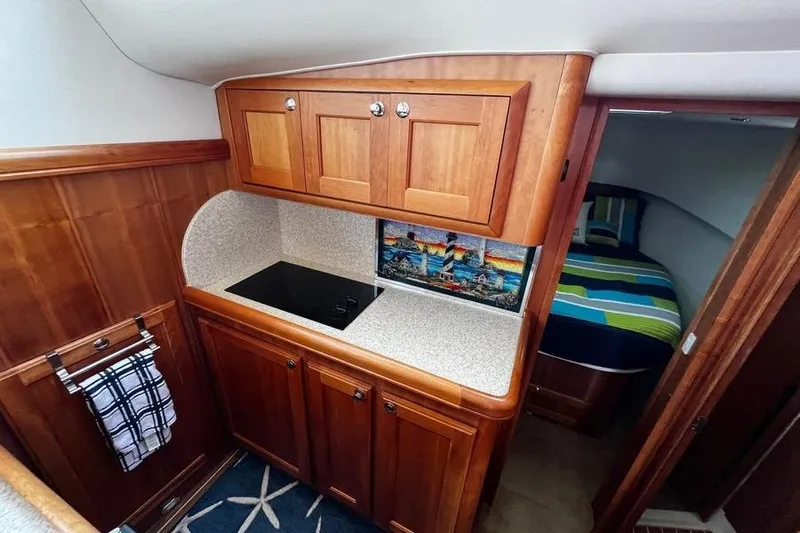  Yacht Photos Pics 2006 Mainship 34 Trawler interior with wooden cabinets and compact kitchen area.