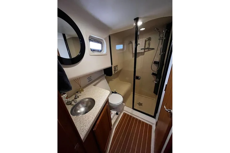  Yacht Photos Pics Bathroom interior of 2006 Mainship 34 Trawler with shower, sink, and toilet.