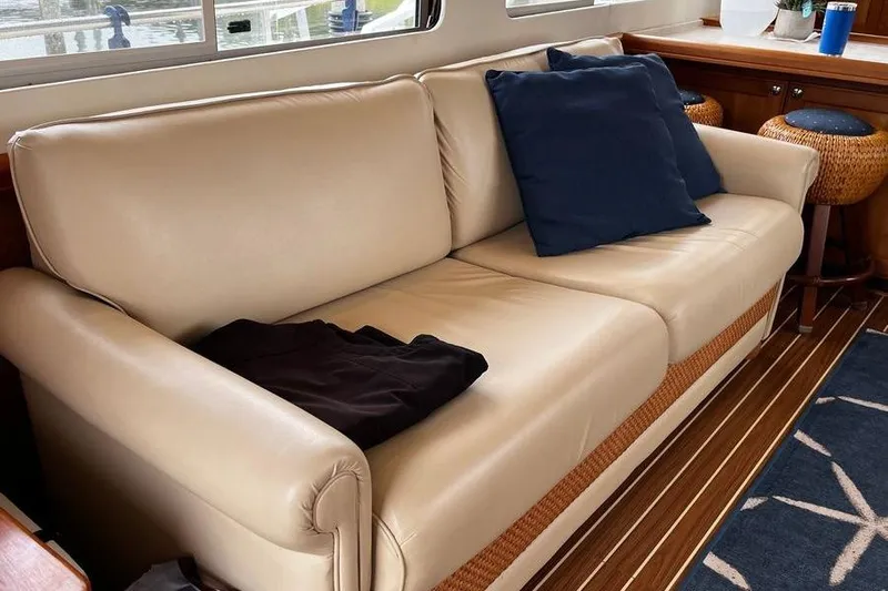  Yacht Photos Pics Luxurious interior of 2006 Mainship 34 Trawler with beige sofa and blue cushions.