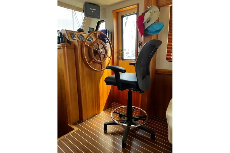  Yacht Photos Pics 2006 Mainship 34 Trawler helm with wooden wheel and adjustable captain's chair.