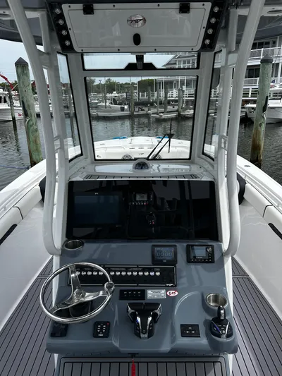  Yacht Photos Pics 2024 Tidewater 280 CC Adventure boat cockpit with advanced navigation controls and marina backdrop.