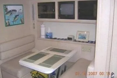  Yacht Photos Pics 1995 Hatteras 39 Sport Express interior with dining area, beige seating, and wall art.