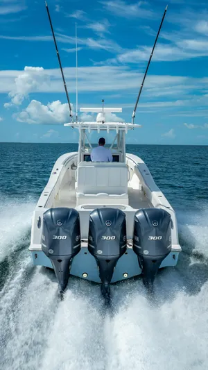  Yacht Photos Pics 2018 Invincible 36 boat with triple outboard engines cruising on open water.