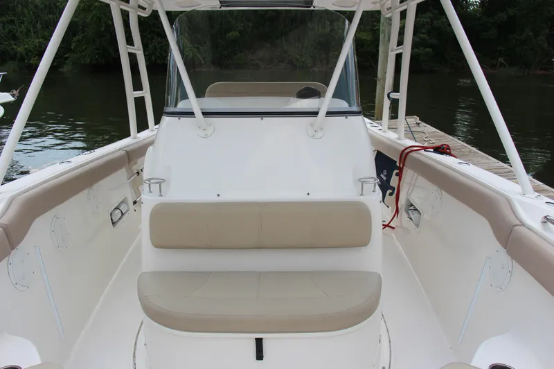  Yacht Photos Pics 2016 Pursuit S 280 Sport boat interior with seating and console, docked by a river.