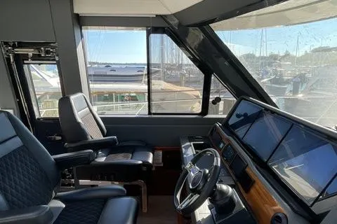  Yacht Photos Pics 2025 Riviera 585 SUV yacht cockpit with modern controls and panoramic marina view.