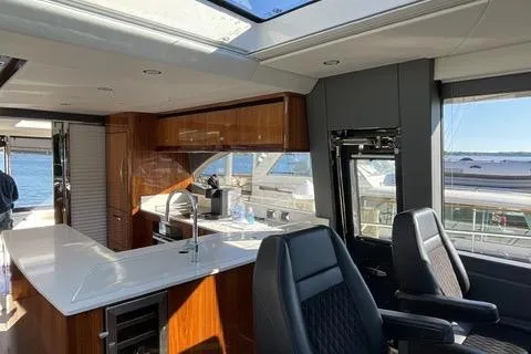  Yacht Photos Pics Luxurious interior of 2025 Riviera 585 SUV yacht with modern kitchen and seating.