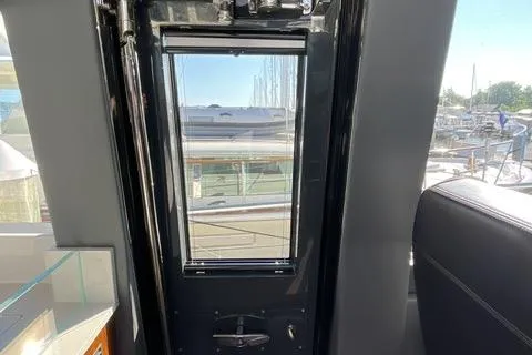  Yacht Photos Pics Interior view of 2025 Riviera 585 SUV yacht, showcasing sleek design and marina backdrop.