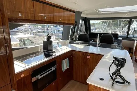  Yacht Photos Pics Luxurious 2025 Riviera 585 SUV yacht interior with modern kitchen and marina view.
