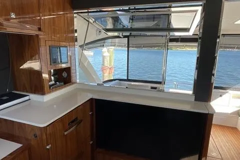  Yacht Photos Pics Luxurious interior of 2025 Riviera 585 SUV yacht with wood finish and water view.