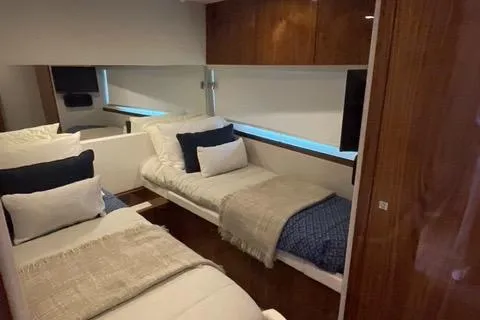  Yacht Photos Pics Interior of 2025 Riviera 585 SUV yacht with twin beds and modern decor.