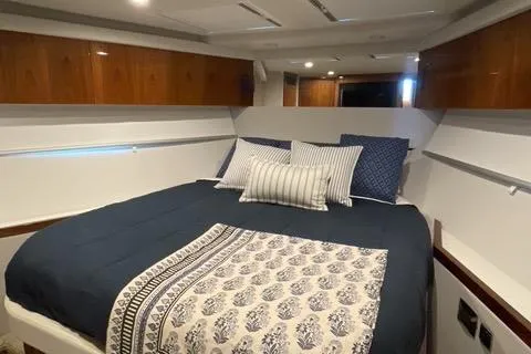  Yacht Photos Pics Luxurious bedroom interior of 2025 Riviera 585 SUV yacht with elegant bedding.
