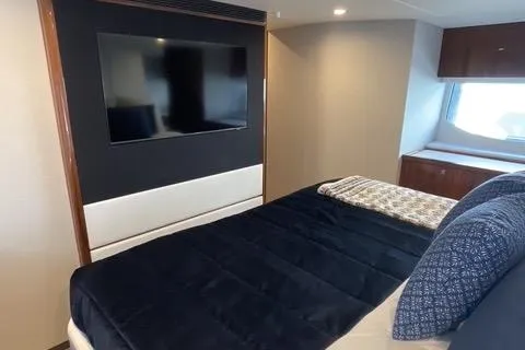  Yacht Photos Pics 2025 Riviera 585 SUV yacht bedroom with TV and modern decor.