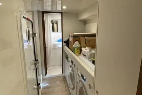  Yacht Photos Pics Laundry area inside 2025 Riviera 585 SUV yacht, featuring modern appliances and storage.