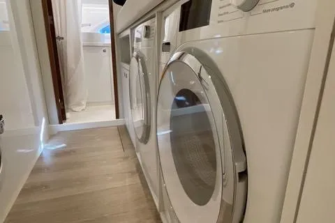  Yacht Photos Pics Laundry area inside 2025 Riviera 585 SUV yacht, featuring modern appliances and sleek design.