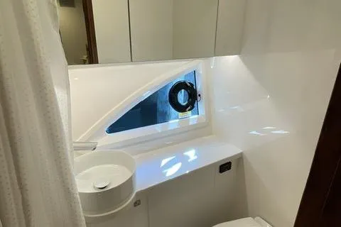  Yacht Photos Pics 2025 Riviera 585 SUV bathroom with modern sink and porthole window.