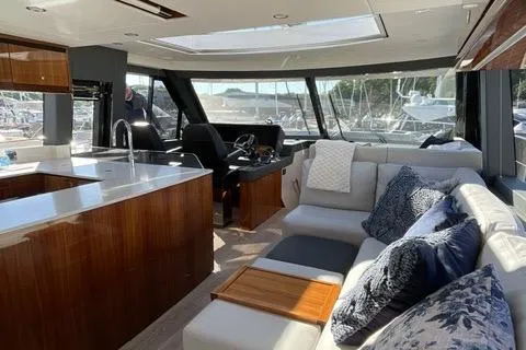  Yacht Photos Pics Luxurious interior of 2025 Riviera 585 SUV yacht with modern kitchen and comfortable seating.