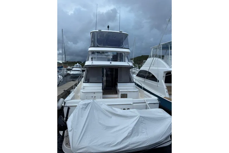  Yacht Photos Pics 2025 Riviera 50 Sports Motor Yacht docked under cloudy skies.