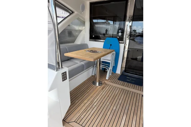  Yacht Photos Pics 2025 Riviera 50 Sports Motor Yacht interior with wooden deck and seating area.