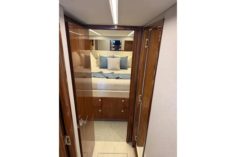 Yacht Photos Pics Luxurious bedroom interior of 2025 Riviera 50 Sports Motor Yacht with elegant wood finish.