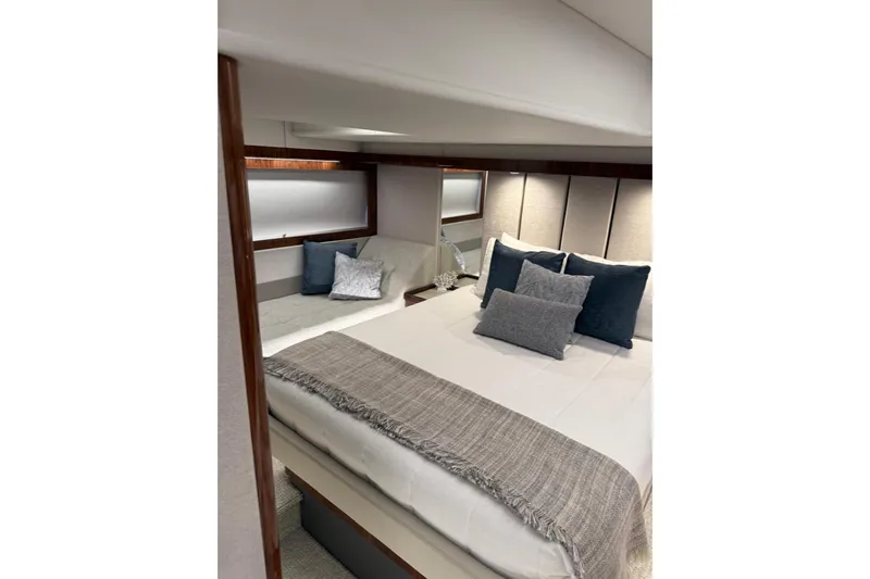 Yacht Photos Pics Luxurious bedroom interior of 2025 Riviera 50 Sports Motor Yacht with elegant bedding.