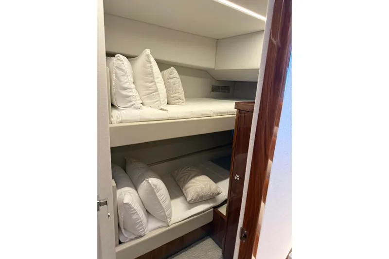  Yacht Photos Pics Bunk beds in 2025 Riviera 50 Sports Motor Yacht cabin, featuring plush white bedding.