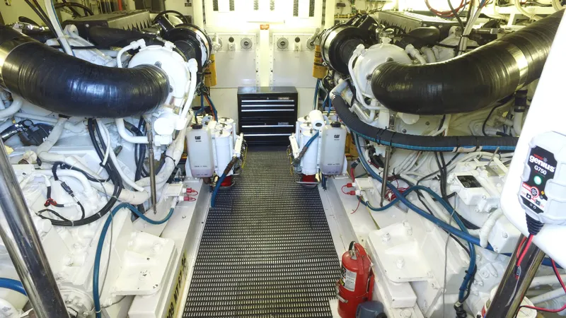 Jolley Roger Yacht Photos Pics Engine room of a 2006 Hatteras Enclosed Bridge yacht, featuring dual engines and equipment.