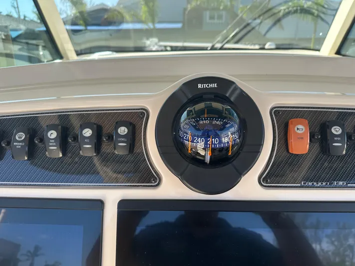  Yacht Photos Pics Dashboard of 2021 Grady-White 336 Canyon boat with compass and control switches.