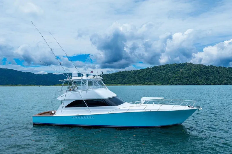 Mariah Jean Yacht Photos Pics 2004 Viking 61c yacht on serene water with lush green hills in the background.