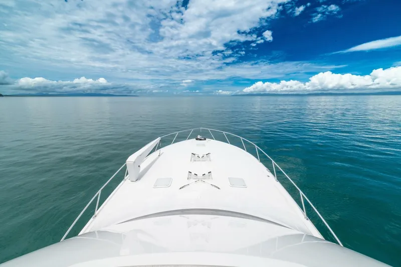 Mariah Jean Yacht Photos Pics Bow view of 2004 Viking 61c yacht on calm ocean under blue sky.