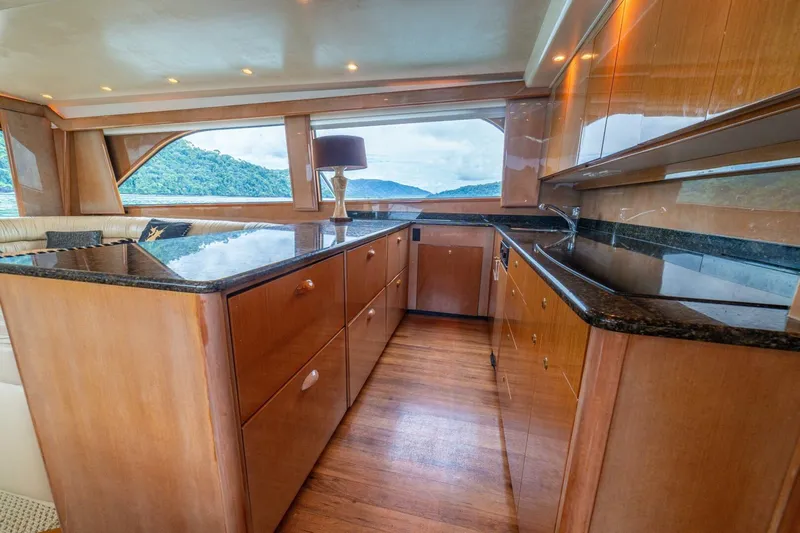 Mariah Jean Yacht Photos Pics Luxurious kitchen interior of 2004 Viking 61c yacht with wood cabinetry and scenic window view.