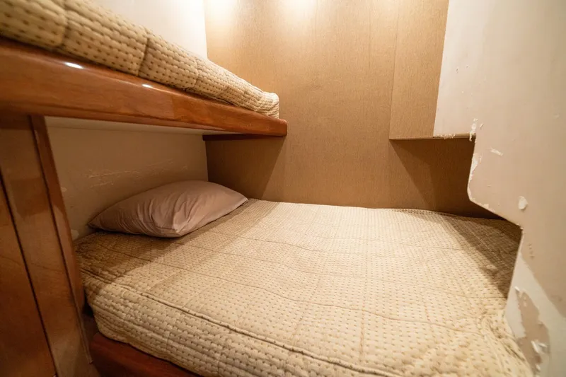 Mariah Jean Yacht Photos Pics Bunk beds in a 2004 Viking 61 Convertible yacht cabin, featuring cozy bedding and wooden accents.