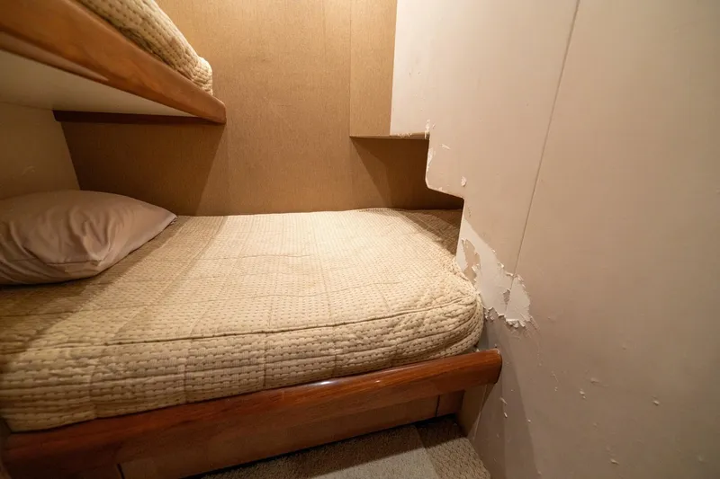 Mariah Jean Yacht Photos Pics Interior cabin of 2004 Viking 61 Convertible yacht with bunk beds and worn wall.