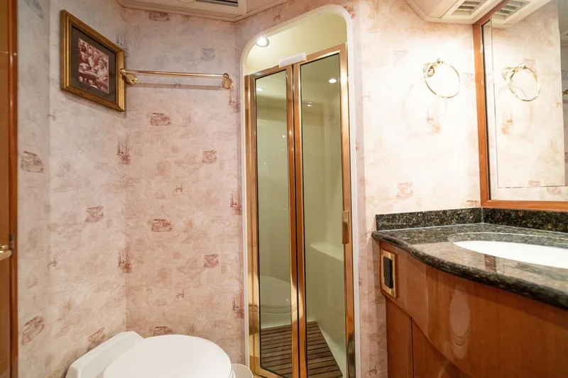 Mariah Jean Yacht Photos Pics Luxurious 2004 Viking 61c yacht bathroom with shower, elegant wallpaper, and granite countertop.