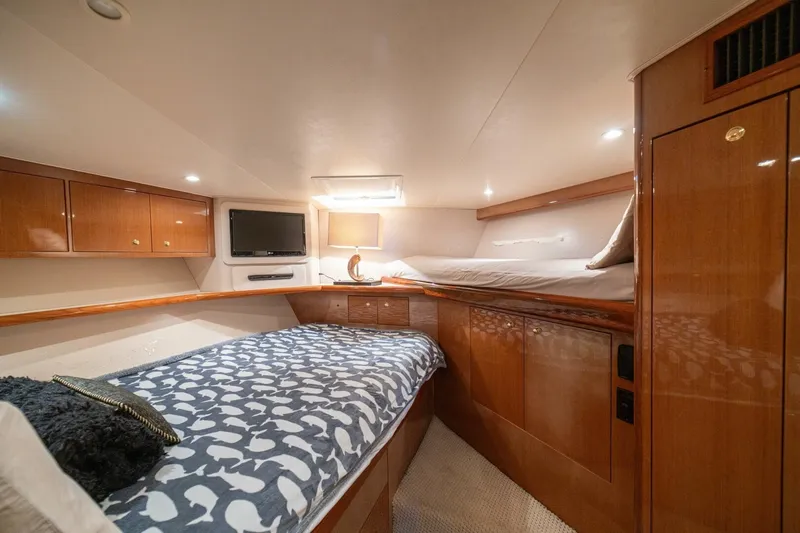 Mariah Jean Yacht Photos Pics Luxurious cabin interior of a 2004 Viking 61c yacht with cozy bedding and wooden cabinetry.