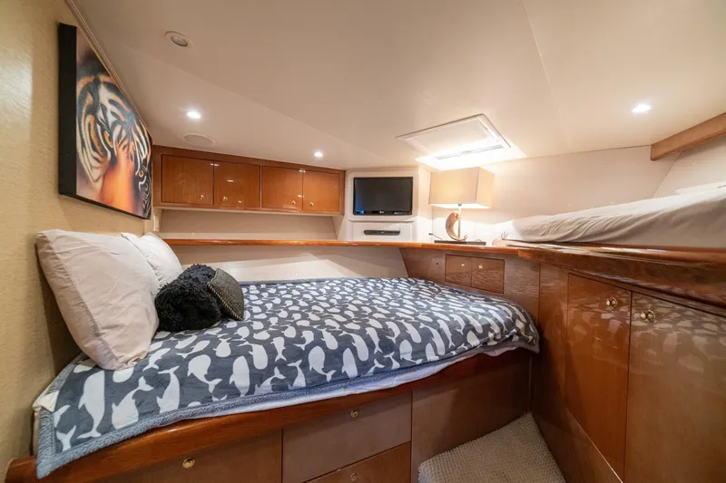 Mariah Jean Yacht Photos Pics Luxurious cabin interior of a 2004 Viking 61c yacht with cozy bedding and elegant wood finishes.
