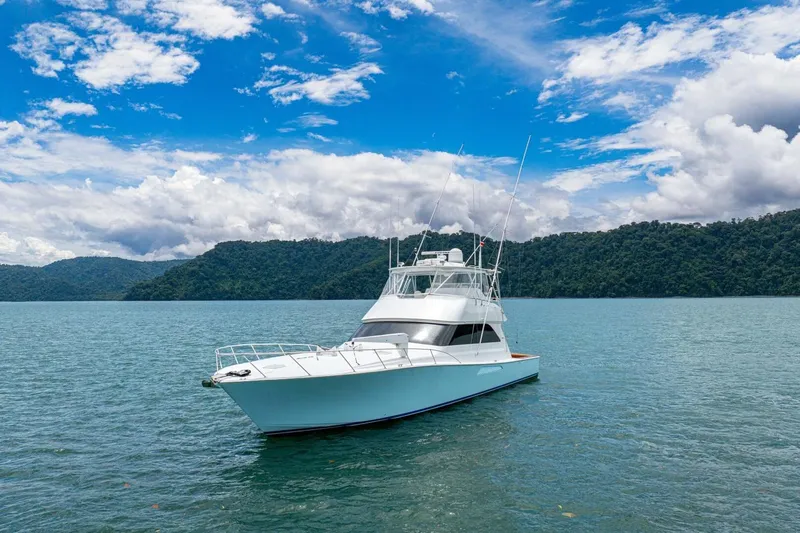 Mariah Jean Yacht Photos Pics 2004 Viking 61c yacht on serene water with lush green hills and blue sky.