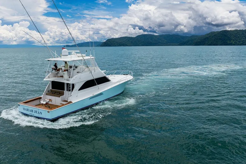 Mariah Jean Yacht Photos Pics 2004 Viking 61c yacht cruising on open water with scenic mountain backdrop.