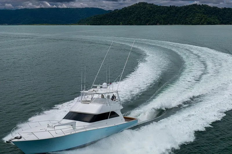 Mariah Jean Yacht Photos Pics 2004 Viking 61c yacht cruising on open water with lush green hills in background.