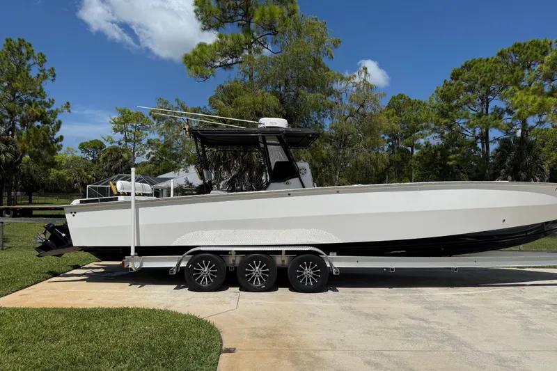  Yacht Photos Pics 2005 Apache 36CC boat on trailer, parked outdoors with trees in background.