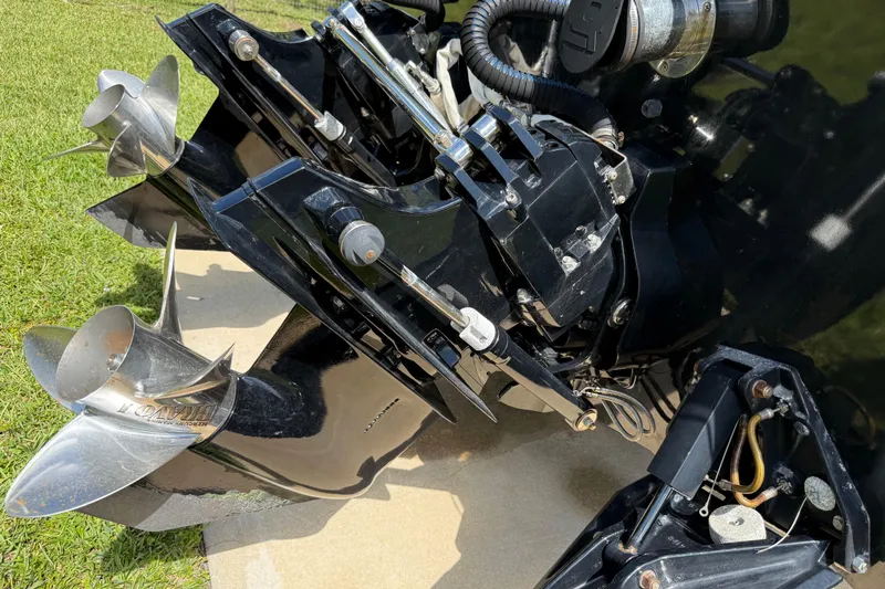  Yacht Photos Pics Close-up of a 2005 Apache 36CC boat engine and propellers on grass.