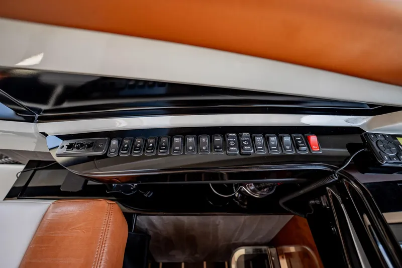 Inverse Entropy Yacht Photos Pics Control panel of a 2009 Marquis 500 Sport Coupe with multiple buttons and leather accents.