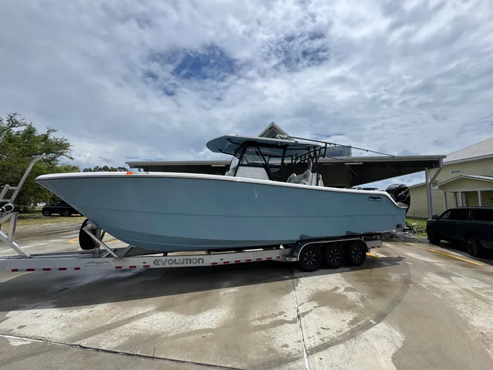  Yacht Photos Pics 2022 Invincible 33 Catamaran on trailer, parked outdoors under cloudy sky.