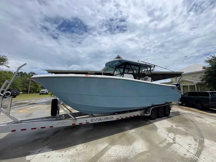  Yacht Photos Pics 2022 Invincible 33 Catamaran on trailer, parked outdoors under cloudy sky.