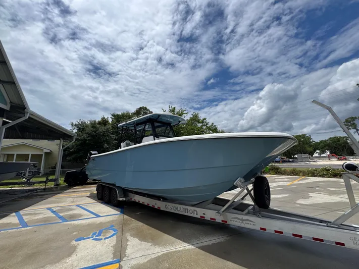  Yacht Photos Pics 2022 Invincible 33 Catamaran on trailer under cloudy sky.
