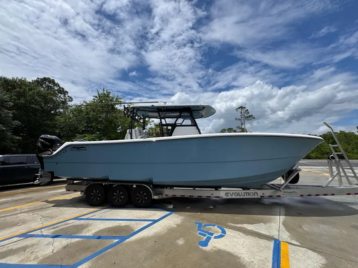  Yacht Photos Pics 2022 Invincible 33 Catamaran on trailer, parked outdoors under cloudy sky.