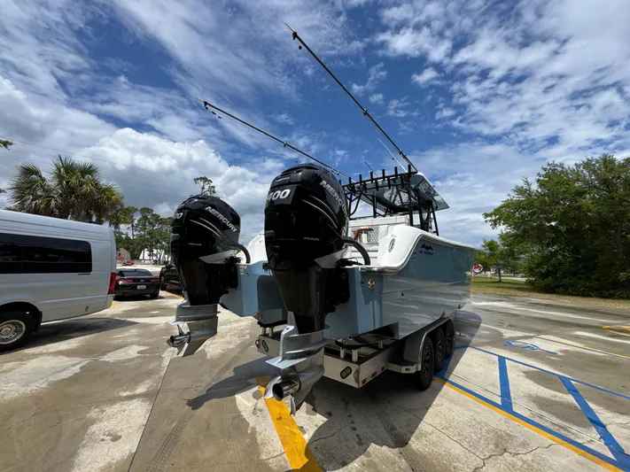  Yacht Photos Pics 2022 Invincible 33 Catamaran with dual outboard engines in a parking lot.