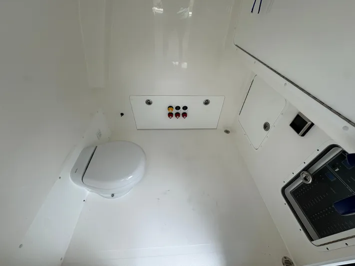  Yacht Photos Pics 2022 Invincible 33 Catamaran interior with marine toilet and control panel.