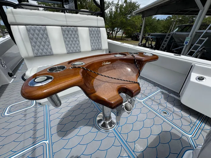  Yacht Photos Pics 2022 Invincible 33 Catamaran with elegant wooden fishing station and cushioned seating.
