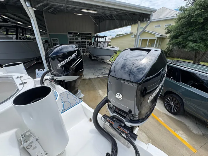  Yacht Photos Pics 2022 Invincible 33 Catamaran with dual Mercury outboard engines in a boatyard setting.