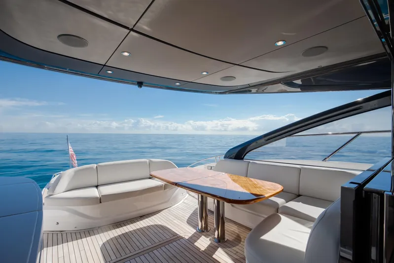 Mermoo Too Yacht Photos Pics Luxurious 2024 Princess V55 yacht interior with ocean view, featuring elegant seating and wooden table.